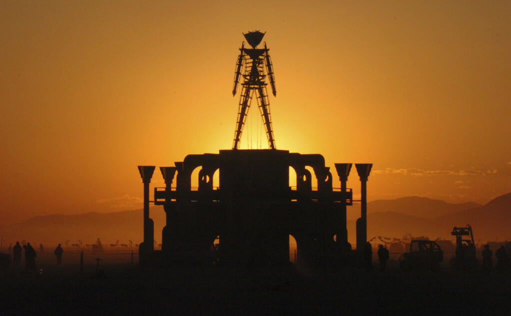 FILE - In this Sept. 2, 2006 file photo, "The Man," a stick figured symbol of the Burning Man art festival, is silhouetted against a morning sunrise in Nevada's Black Rock Desert.  (AP Photo/Ron Lewis, File)