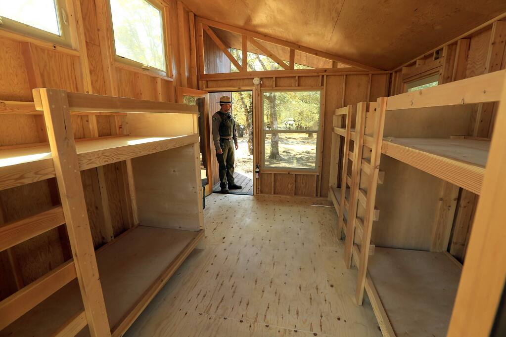 Supervising Park Ranger Jonathan Umholtz opens one of the three new wedge cabins, designed by Cal Poly Pomona students, being installed at the Spring Lake Campground in Santa Rosa. Each cabin will sleep 4-6 people. (JOHN BURGESS/The Press Democrat)