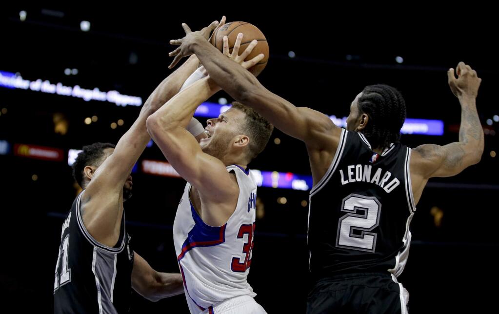 Los Angeles Clippers forward Blake Griffin, middle, shot is blocked by San Antonio Spurs forward Tim Duncan, left, and forward Kawhi Leonard during the second half of Game 2 of a first-round NBA basketball playoff series in Los Angeles, Wednesday, April 22, 2015. The Spurs won 111-107 in overtime. (AP Photo/Chris Carlson)