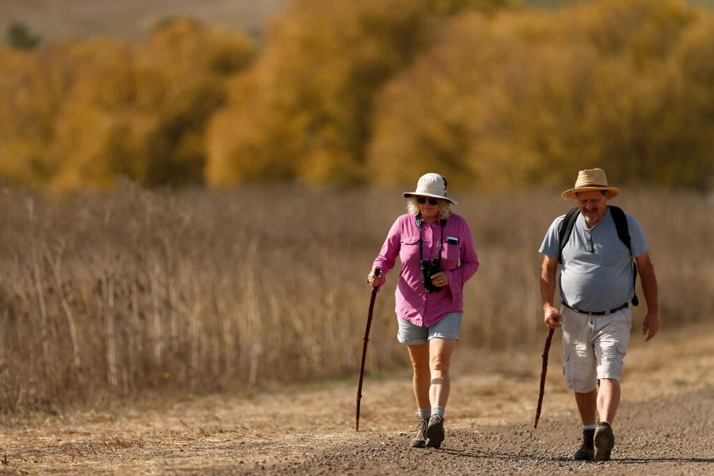 Peggy Ruffra, left, and Dan Williams, both of Novato, head down the Causeway Trail for some bird watching at Tolay Lake Regional Park in Petaluma on Saturday, Oct. 27, 2018. (Alvin Jornada / The Press Democrat)