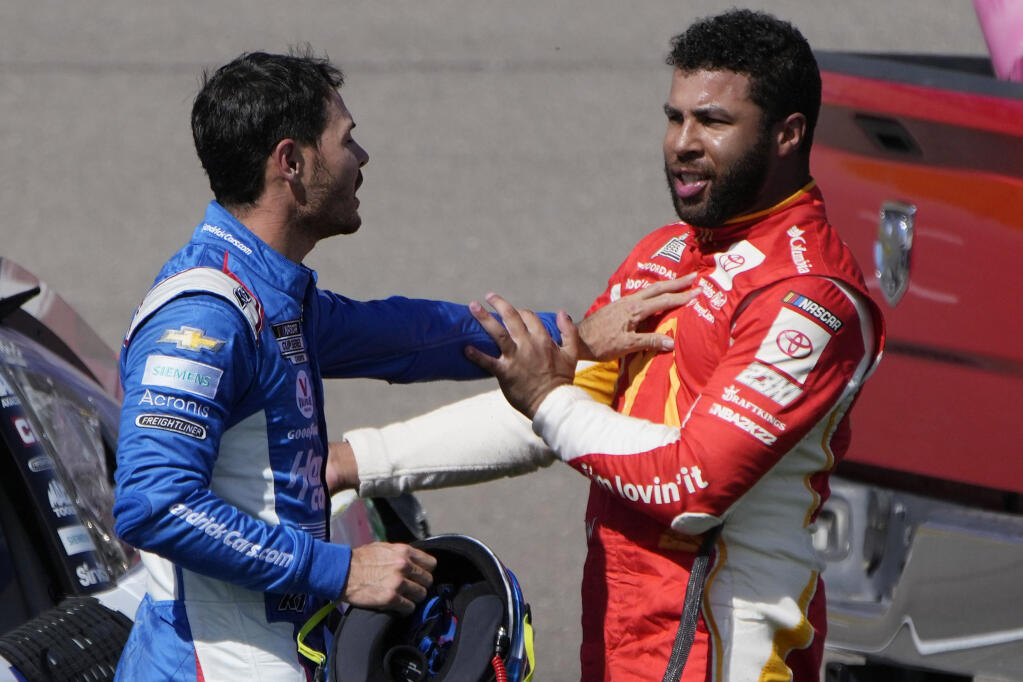 Bubba Wallace, right, and Kyle Larson push each other away after the two crashed during a NASCAR Cup Series auto race Sunday, Oct. 16, 2022, in Las Vegas. (AP Photo/John Locher)