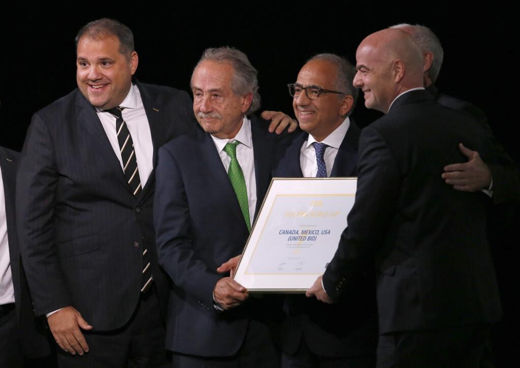 Delegates of Canada, Mexico and the United States celebrate with FIFA President Gianni Infantino, right, after winning a joint bid to host the 2026 World Cup at the FIFA congress in Moscow, Russia, Wednesday, June 13, 2018. From left: Victor Montagliani the president of CONCACAF, Decio de Maria, President of the Football Association of Mexico, Carlos Cordeiro, U.S. soccer president and Steve Reed, president of the Canadian Soccer Association (covered by Infantino). (AP Photo/Alexander Zemlianichenko)