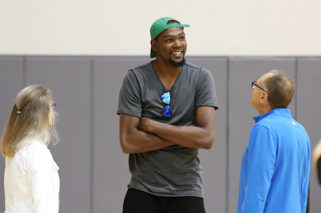 Kevin Durant talks with Golden State Warriors Assistant Coach Ron Adams, right, before a news conference about Durant joining the Warriors at the NBA basketball team's practice facility, Thursday, July 7, 2016, in Oakland, Calif. (AP Photo/Beck Diefenbach)