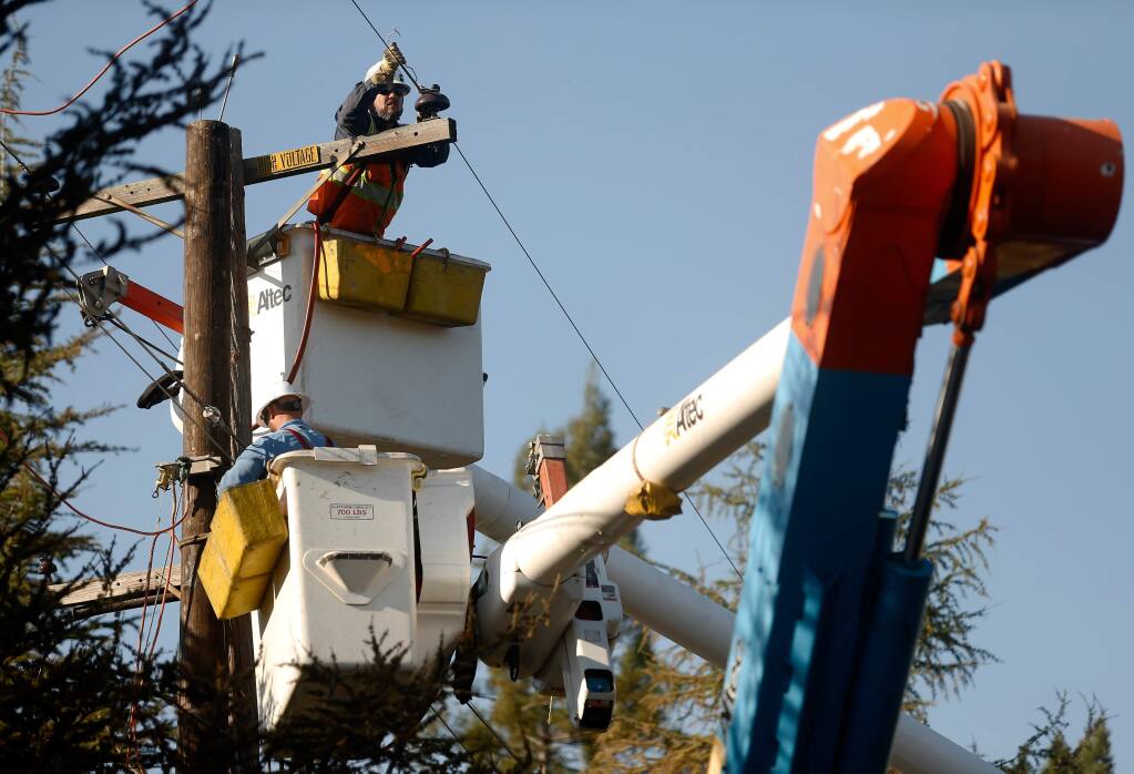 A PG&E crew repairs power lines destroyed by the Tubbs fire along Wikiup Drive in Santa Rosa, California on Wednesday, Oct. 18, 2017. (ALVIN JORNADA/ PD)