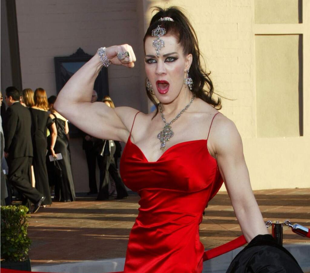 FILE - In this Nov. 16, 2003 file photo, Joanie Laurer, former pro wrestler known as Chyna, flexes her bicep as she arrives at the 31st annual American Music Awards, in Los Angeles. Chyna, the WWE star who became one of the best known and most popular female professional wrestlers in history in the late 1990s, has died at age 45. Los Angeles County coronerís Lt. Larry Dietz says Chyna, whose real name is Joan Marie Laurer, was found dead in Redondo Beach on Wednesday, April 20, 2016. (AP Photo/Kevork Djansezian, File)