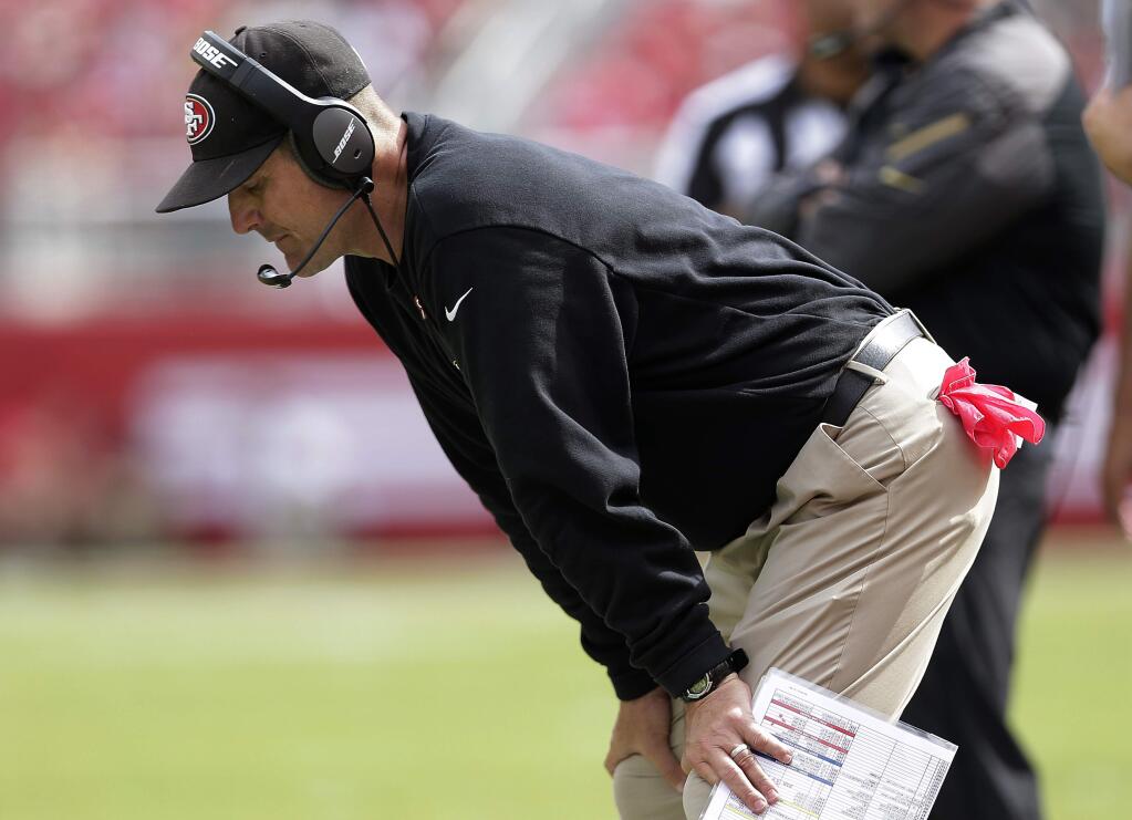 San Francisco 49ers coach Jim Harbaugh looks down along the sideline during the first half of the 49ers' NFL football game against the Philadelphia Eagles in Santa Clara, Calif., Sunday, Sept. 28, 2014. (AP Photo/Marcio Jose Sanchez)