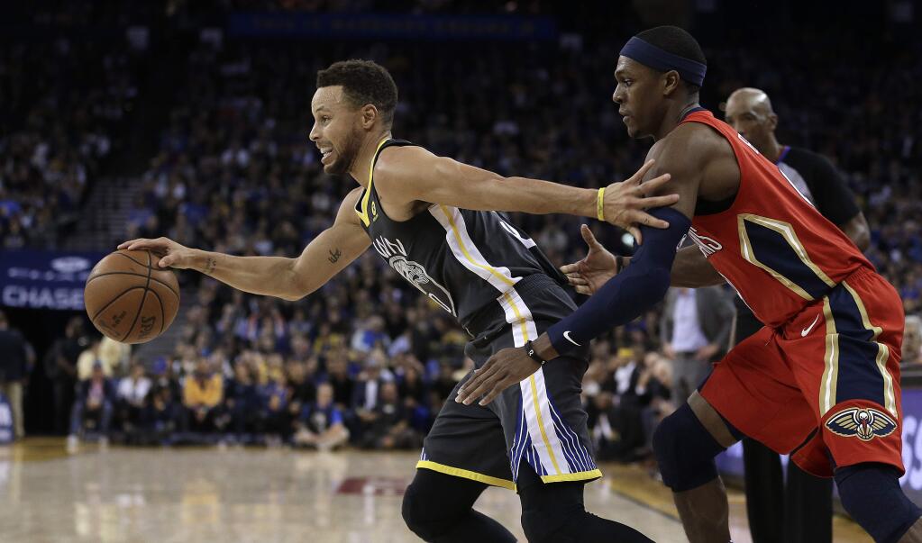 Golden State Warriors guard Stephen Curry, left, drives the ball away from New Orleans Pelicans guard Rajon Rondo during the second half Saturday, Nov. 25, 2017, in Oakland. The Warriors won, 110-95. (AP Photo/Ben Margot)
