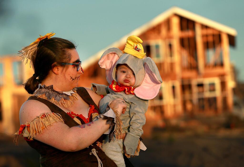 Scarecrow Melissa Geissinger adjusts the elephant costume on Apollo, 10 months, in Coffey Park on Halloween. The residents and friends decorated their cars and passed out candy during a Trunk or Treat Halloween evening for the children who lost their homes in the Tubbs Fire. (John Burgess/The Press Democrat)