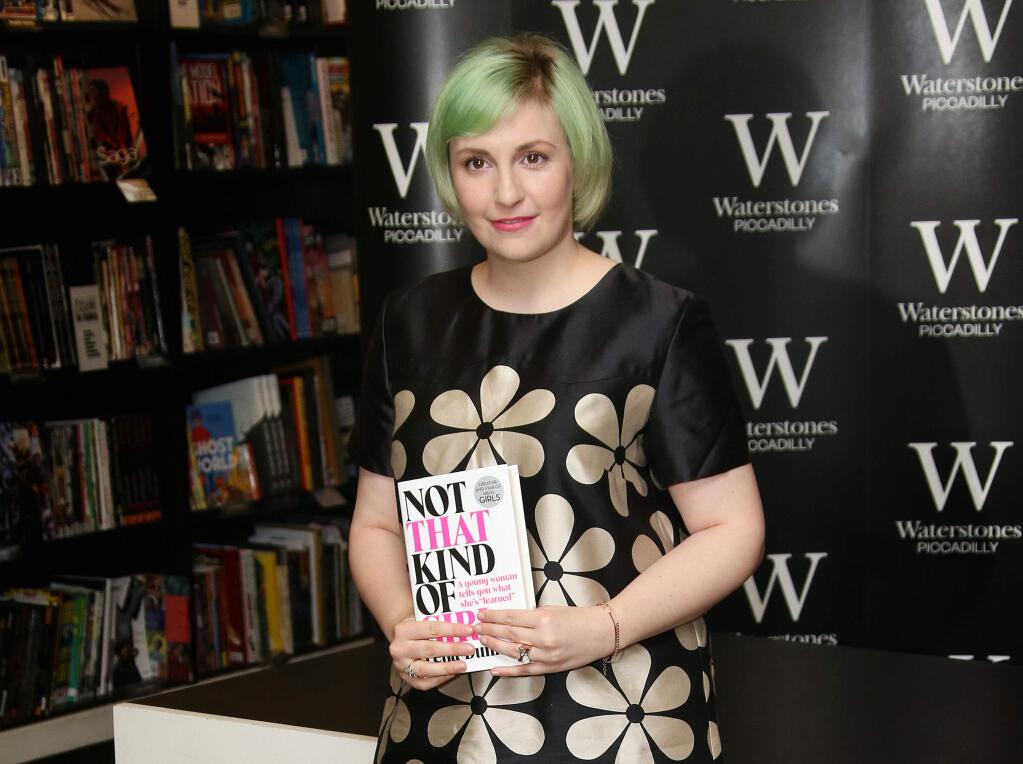 FILE - In this Oct. 29, 2014 file photo, U.S actress Lena Dunham holds her memoir, Not That Kind Of Girl, ahead of a book signing at Waterstones book shop, Piccadilly in central London. (Photo by Joel Ryan/Invision/AP, File)