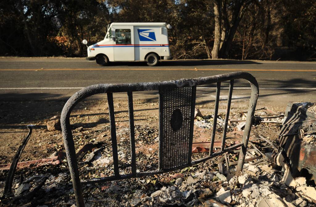 Geyserville's mail carrier Bernadette Laos passes by her burned home at the intersection of Geysers Road and Red Winery Road, Wednesday, Nov. 6, 2019 as she delivers mail. Laos lost her home to the Kiincade fire. (Kent Porter / The Press Democrat) 2019