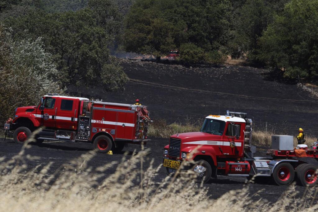 Firefighters from Marin and Sonoma counties work to put out a grass fire off of Sonoma Mountain Road between Petaluma and Glen Ellen on Tuesday, June 23, 2015. (SCOTT MANCHESTER/ARGUS-COURIER STAFF)