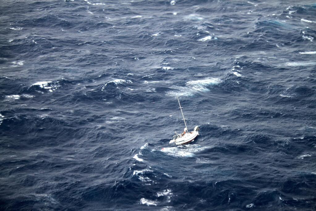 This Sunday, Aug. 10, 2014 photo provided by the U.S. Coast Guard shows the 42-foot sailboat Walkabout caught in Hurricane Julio, about 400 miles northeast of Oahu, Hawaii. Walkabout is disabled and taking on water with three people aboard. The Coast Guard is coordinating the rescue of the boat. (AP Photo/U.S. Coast Guard)