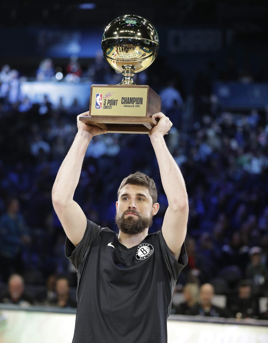 Brooklyn Nets Joe Harris holds the champion trophy after winning the NBA All-Star 3-Point contest, Saturday, Feb. 16, 2019, in Charlotte, N.C. (AP Photo/Chuck Burton)