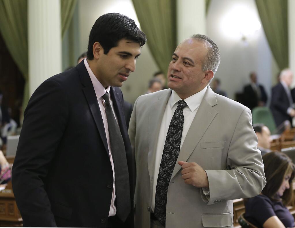 Assemblyman Raul Bocanegra, D-Pacoima, right, discusses a bill with Assemblyman Matt Dababneh, D-Van Nuys at the Capitol in Sacramento, Calif., Thursday, Aug. 28, 2014. By a 54-12 vote, lawmakers approved a bill co-authored by Bocanegra and Assembly Reginald Jones-Sawyer, D-Los Angeles, that would prohibit sports franchise owners like Donald Sterling from writing off fines imposed by sports leagues as business expenses. (AP Photo/Rich Pedroncelli)