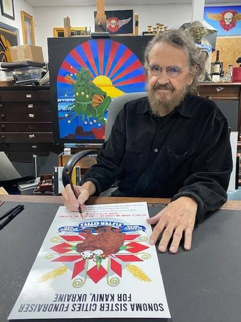 Photo Stanley Mouse, a local artists who became famous from his 60s era rock-n-roll posters of the Grateful Dead and other bands at the Fillmore in San Francisco, signing an original vintage poster from 1988. (Photo provided by Kaeti Baili)