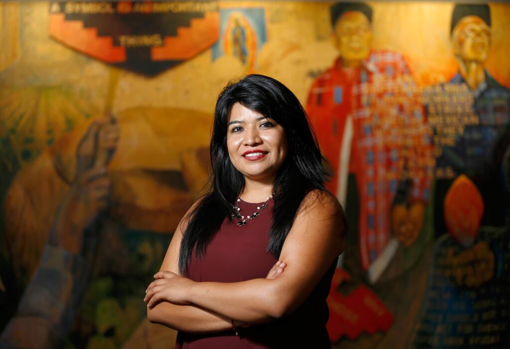Ariana Aparicio poses for a portrait in front of the Cesar E. Chavez Memorial mural at the Sonoma State University library. Aparicio, an academic advisor at the university's Undocu-Resource Center, is enrolling at Harvard University this fall. (ALVIN JORNADA / The Press Democrat)