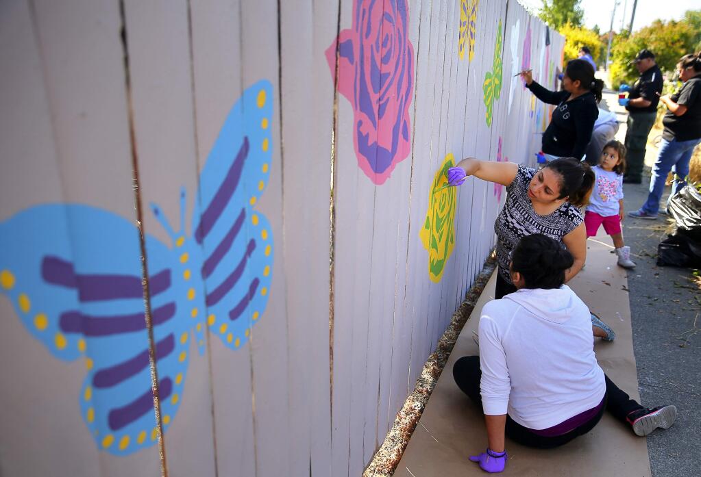 Maritza Ortiz, right, and Gisell Ambriz, both with Community Action Partnership, help paint a mural along Moorland Avenue during the Day of Caring, in Santa Rosa, on Wednesday, September 14, 2016. (Christopher Chung/ The Press Democrat)