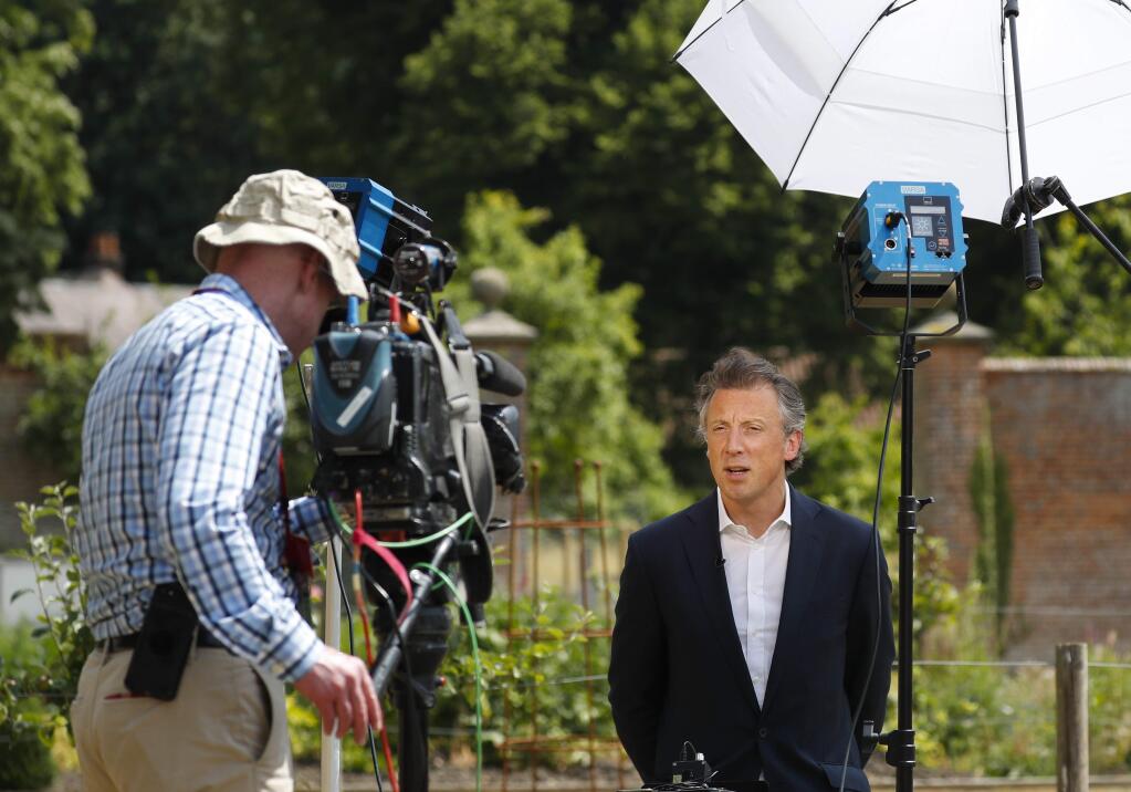 Tom Newton Dunn, Political Editor of the Sun Newspaper, right, is seen speaking to Fox Television News network at Chequers, in Buckinghamshire, England, Friday, July 13, 2018. In an interview with Sun newspaper, President Donald Trump slammed British Prime Minister Theresa May's plan for British departure from the Europe Union and praised her political rival Boris Johnson, who quit May's Cabinet this week over Brexit differences. (AP Photo/Pablo Martinez Monsivais)