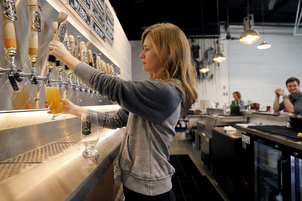 Annie Battaglia pours cider on tap for customers at Sonoma Cider taproom in Healdsburg, on Friday, February 3, 2017. (BETH SCHLANKER/ The Press Democrat)