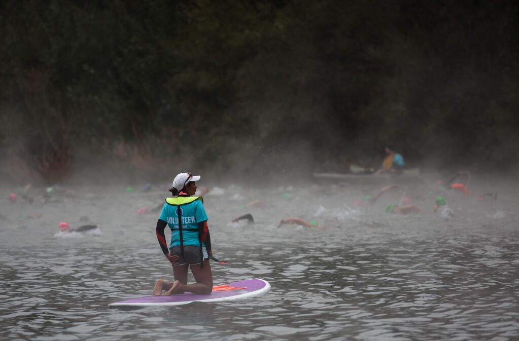 A volunteer on a paddle board keeping athletes in line on the Russian River at Johnson's Beach in Guerneville.