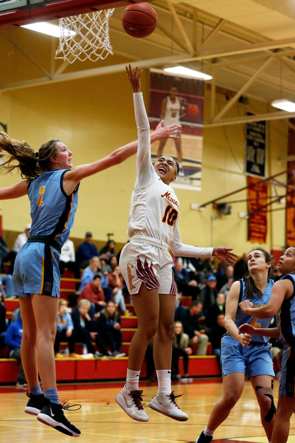 Cardinal Newman's Anya Choice, center, scores two past Heritage's Amanda Muse, left, during the first half of the NCS Open Division playoff game in Santa Rosa on Thursday, February 20, 2020. (Alvin Jornada / The Press Democrat)