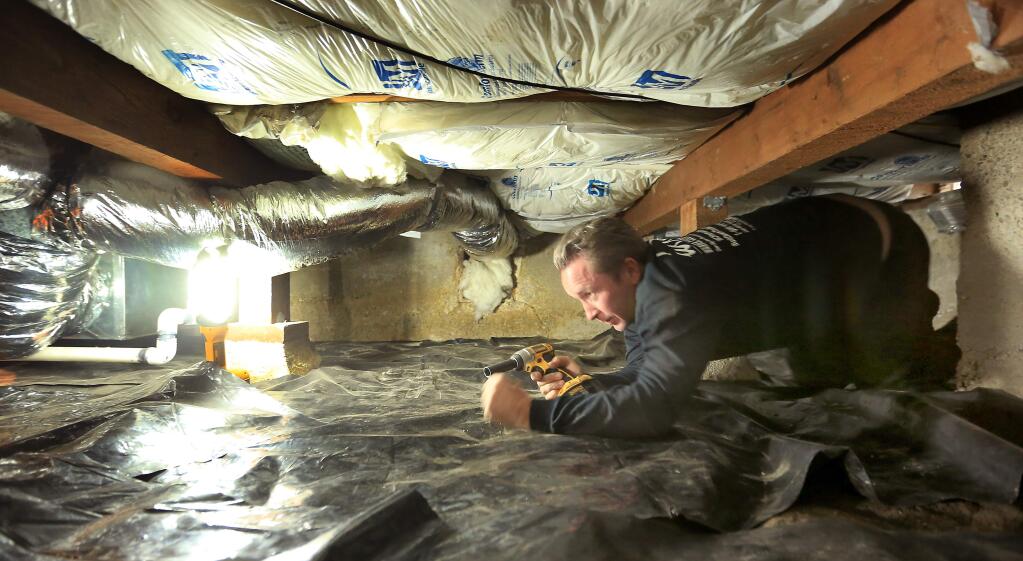 Sean Warner, owner of Bolt Down the Bay Area, tightens earthquake protection hardware on a home in Santa Rosa, Friday Oct. 17, 2014. (Kent Porter / Press Democrat) 2014
