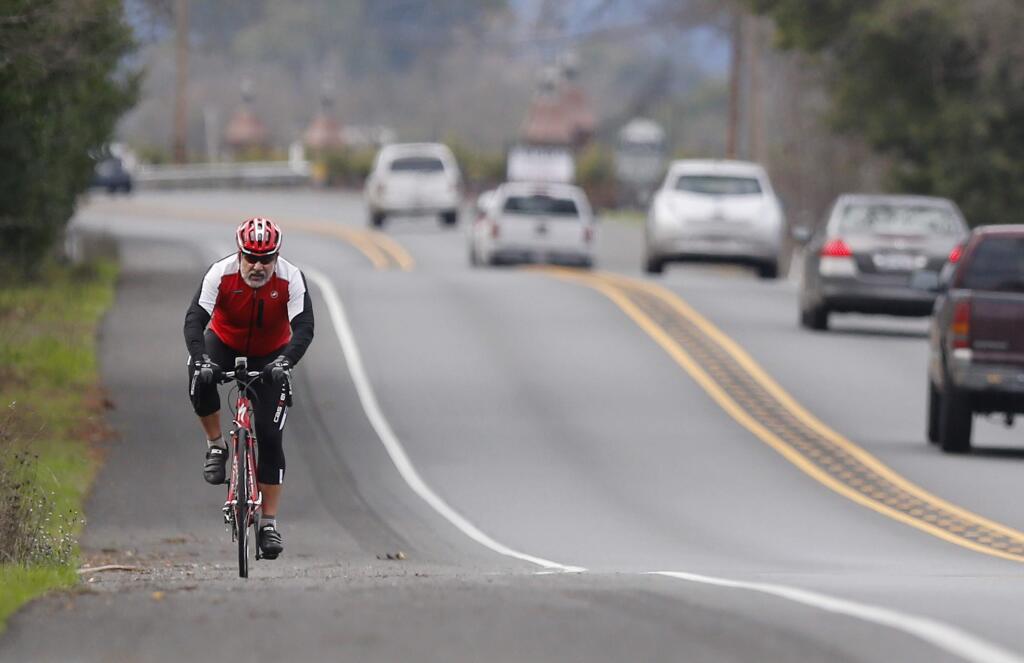 A cyclist rides along the shoulder of Highway 12 on Monday, Jan.11, 2016 in Kenwood. (BETH SCHLANKER / The Press Democrat)