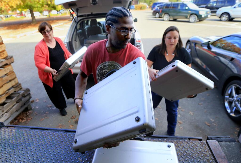 (left to right) Sharon Stevens, Deverick Landrum and Melissa Sadler return voting booths used by Piner High school students to the Registrar of Voters office in Santa Rosa on Tuesday, Oct. 11, 2016. (JOHN BURGESS/ PD FILE)