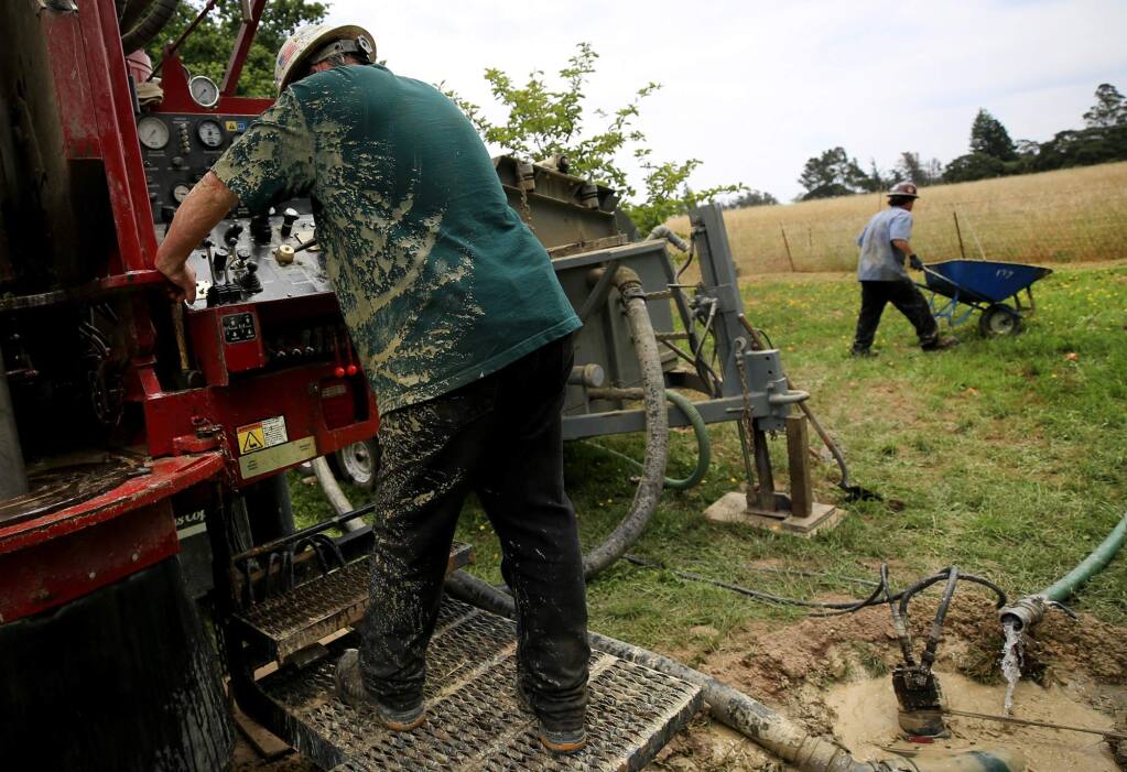 Robert Burgess, left, and Drake Coffey of Weeks Drilling & Pump Co.drill a residential water well near Cotati on Wednesday, June 7, 2017. (KENT PORTER/ PD)
