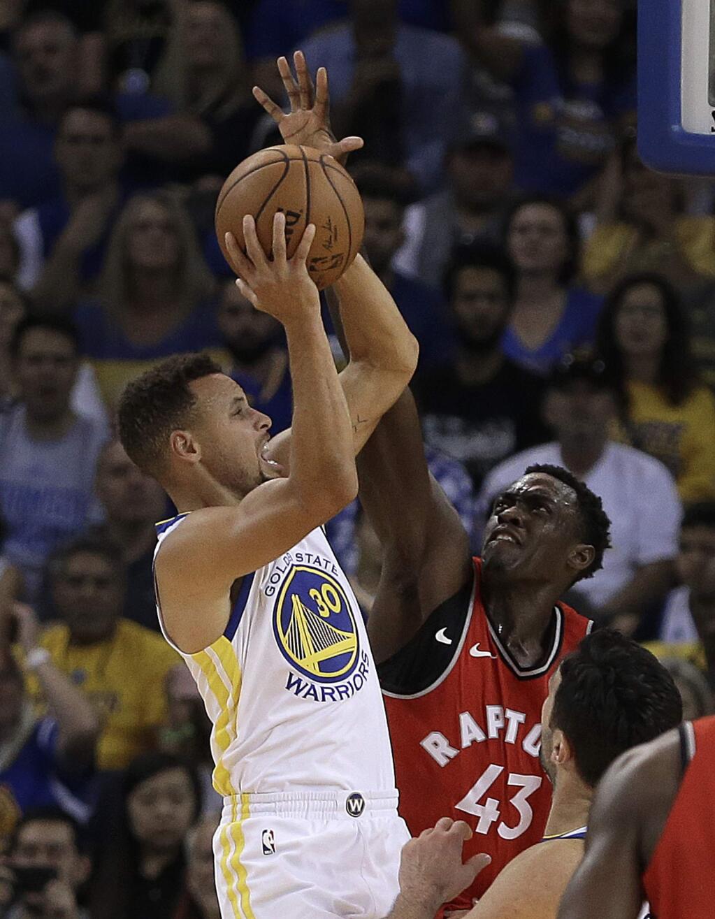Golden State Warriors' Stephen Curry, left, shoots against Toronto Raptors' Pascal Siakam during the first half of an NBA basketball game Wednesday, Oct. 25, 2017, in Oakland, Calif. (AP Photo/Ben Margot)