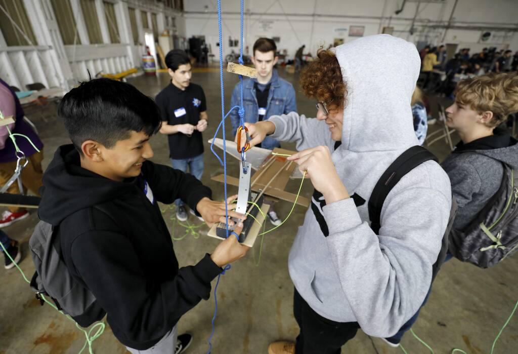 Windsor High School students Alex Pacheco, 14, left, and Carlos Lara, 14, work on creating a glider to safely deliver an egg from 20 feet up in the air during an event hosted by Windsor High's Axis STEM Academy. Photo taken at the Sonoma Jet Center in Napa on Thursday, January 31, 2019. (BETH SCHLANKER/ The Press Democrat)