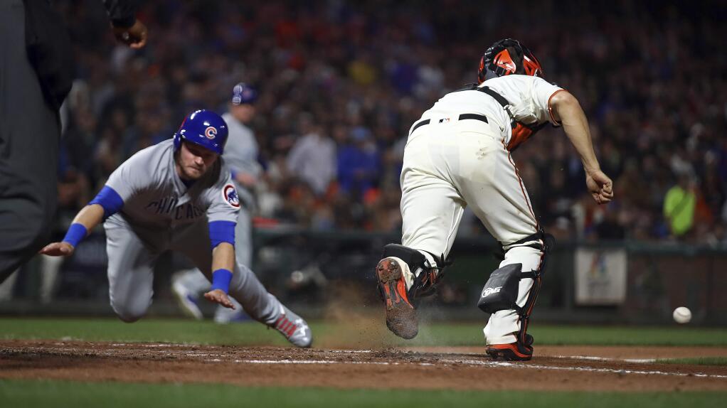 The Chicago Cubs' Ian Happ, left, scores behind the San Francisco Giants' Nick Hundley during the seventh inning Tuesday, July 10, 2018, in San Francisco. (AP Photo/Ben Margot)