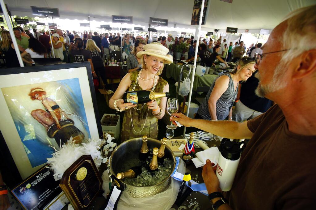 Lori Fantozzi pours samples of Breathless Wines pours samples their bubbling wines at Saturday's Taste of Sonoma event in Healdsburg, August 30, 2014. (Conner Jay/Press Democrat)