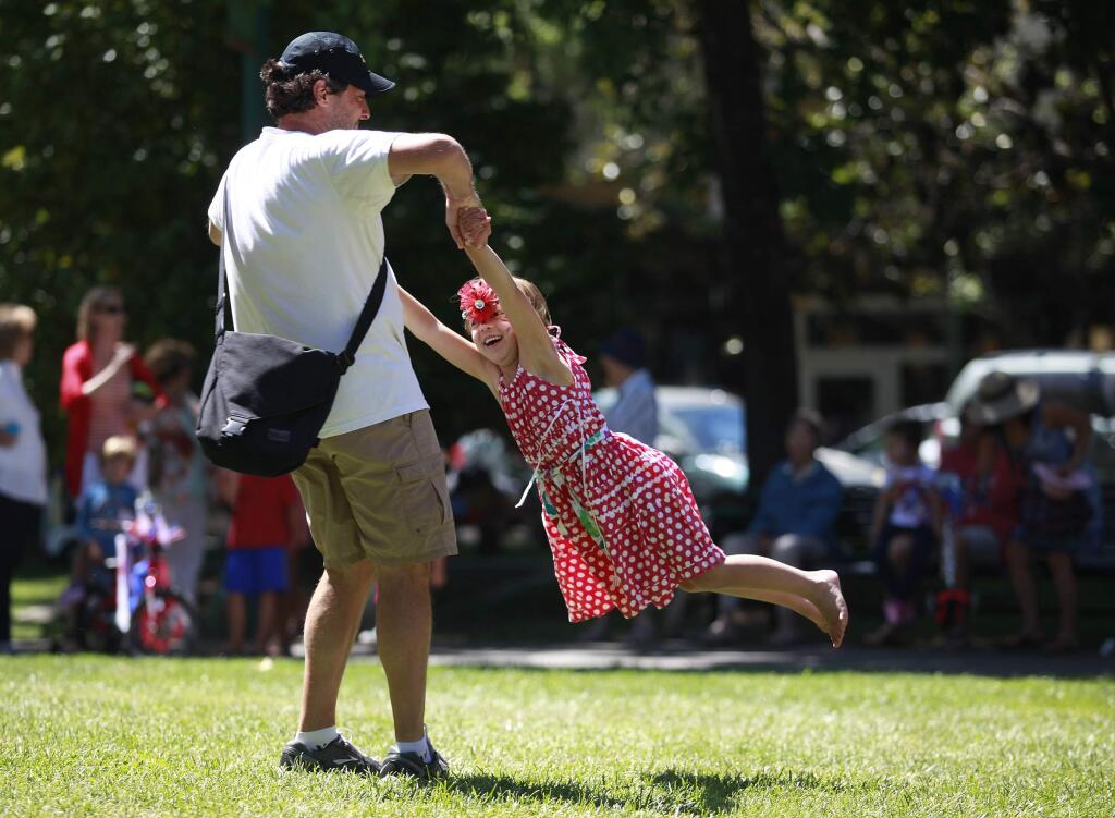 Matt Villano swings his daughter Lily, 5, after the 4th of July Kid's Parade at the plaza in Healdsburg, on Friday, July 4, 2014.(BETH SCHLANKER/ The Press Democrat)