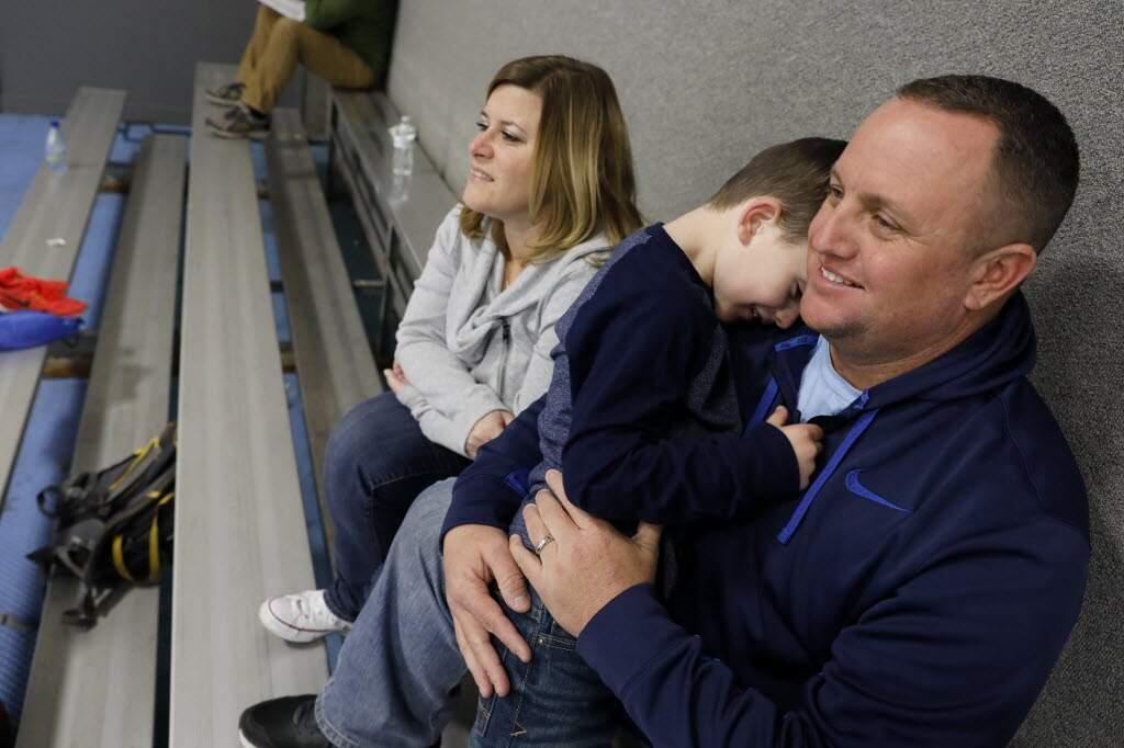 BETH SCHLANKER/THE PRESS DEMOCRATNew St. Vincent DePaul High School football coach John Antonio with wife Kentra and son Connor. They are watching older son, Andrew, practice basketball. Both John and Kendra are St. Vincent graduates.