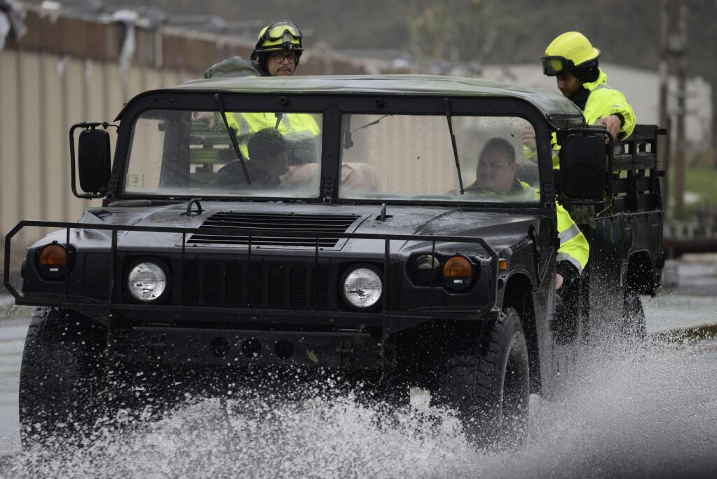 Rescue personnel from the Emergency Management Agency drive through a flooded road after Hurricane Maria hit the eastern region of the island, in Humacao, Puerto Rico, Tuesday, September 20, 2017. The strongest hurricane to hit Puerto Rico in more than 80 years destroyed hundreds of homes, knocked out power across the entire island and turned some streets into raging rivers in an onslaught that could plunge the U.S. territory deeper into financial crisis. (AP Photo/Carlos Giusti)