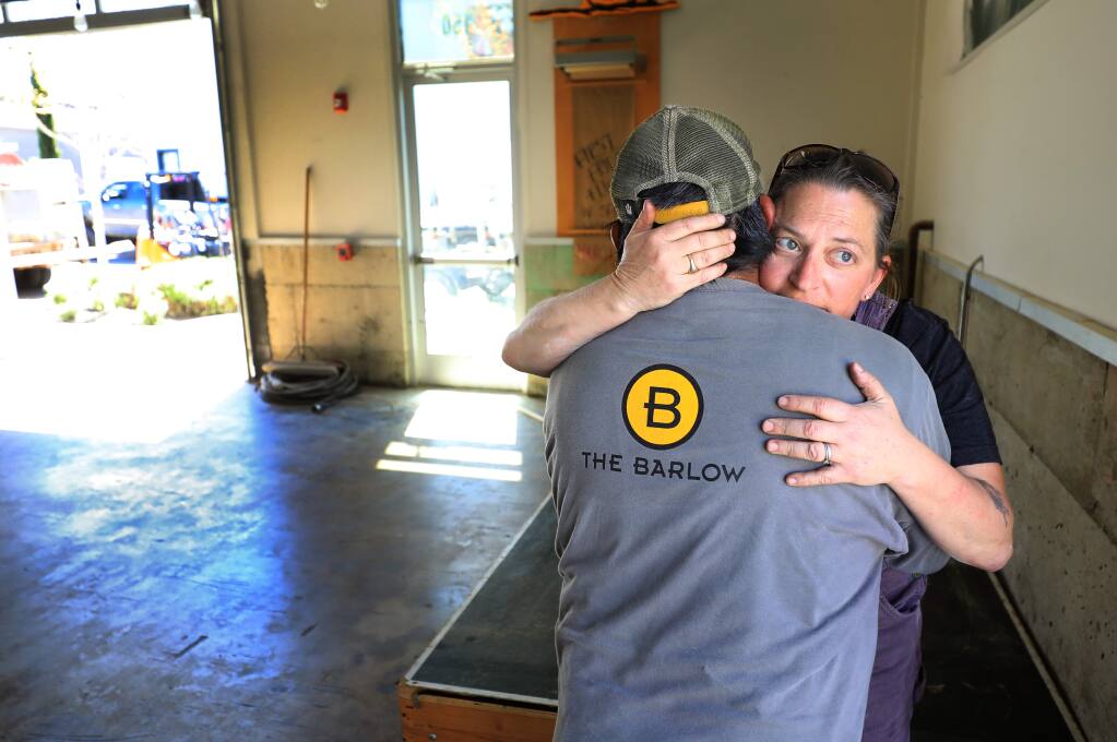 Zazu Kitchen and Farm Duskie Estes embraces Tomas Guzman, part of the maintenance crew of The Barlow, Thursday, April 18, 2019 in Sebastopol. Estes and her husband John Stewart pulled all of their equipment out of the restaurant on Thursday after February flooding of the Laguna shut them down. (Kent Porter / Press Democrat) 2019