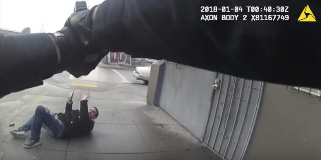This Jan. 3, 2018 still image taken from video from a Bay Area Rapid Transit police officer's body-worn camera released by BART, shows the officer responding to an armed struggle across the street from the West Oakland Station in Oakland, Calif. The transit agency released the image and the video recording on Wednesday showing the officer fatally shooting a man fighting with another man. BART released the 52-second video clip on Wednesday, Feb. 21, 2018, that shows Officer Joseph Mateu shooting 28-year-old Sahleem Tindle, who officials say first shot the other man in Oakland. (Bay Area Rapid Transit via AP)