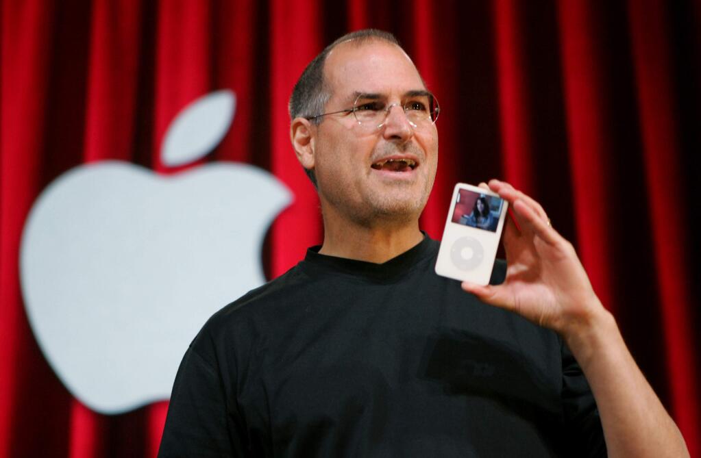 FILE - In this Oct. 12, 2005 file photo, Apple Computer Inc. CEO Steve Jobs holds up an iPod during an event in San Jose, Calif. Jurors in a class-action lawsuit against Apple Inc. on Tuesday, Dec. 2, 2014 saw emails from the late CEO and his top lieutenants that show Jobs was determined to keep Apple's popular iPod music players free from songs that were sold by competing online stores. (AP Photo/Paul Sakuma, File)