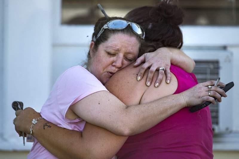 Carrie Matula embraces a woman after a fatal shooting at the First Baptist Church in Sutherland Springs, Texas, Sunday, Nov. 5, 2017. Matula said she heard the shooting from the gas station where she works a block away. (Nick Wagner/Austin American-Statesman via AP)