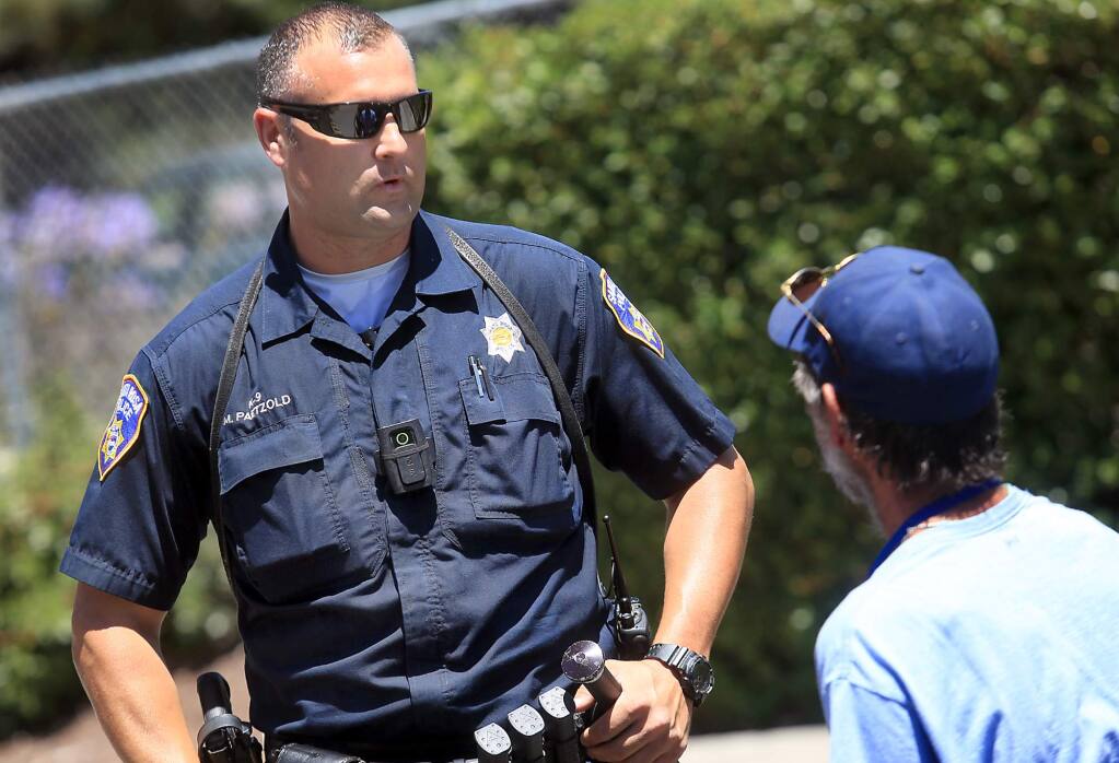 Santa Rosa police officer Mike Paetzold talks with a man that was causing a disturbance in Santa Rosa, Tuesday July 12, 2016. Both Santa Rosa and Sonoma County sheriff's officers are among local law enforcement required to wear body cameras. (Kent Porter / Press Democrat) 2016