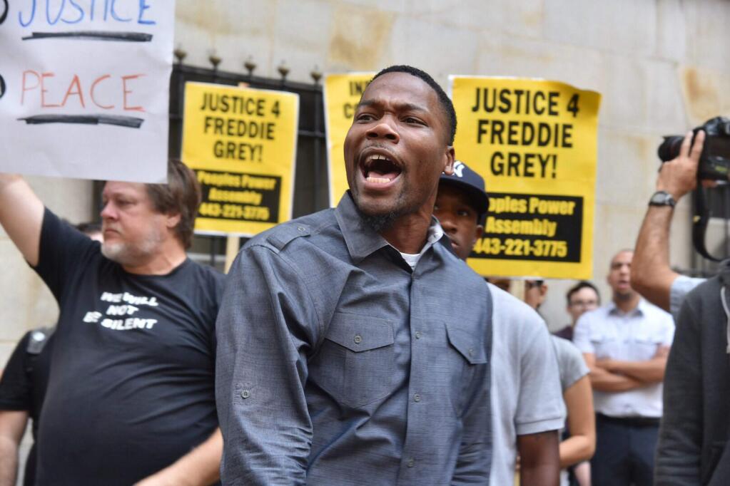 Protesters gather outside Baltimore Circuit Court, as the first court hearing was set to begin in the case of six police officers criminally charged in the death of Freddie Gray, on Wednesday, Sept. 2, 2015 in Baltimore. Six police officers face charges that range from second-degree assault, a misdemeanor, to second-degree 'depraved-heart' murder. (Kim Hairston/The Baltimore Sun via AP) WASHINGTON EXAMINER OUT; MANDATORY CREDIT (