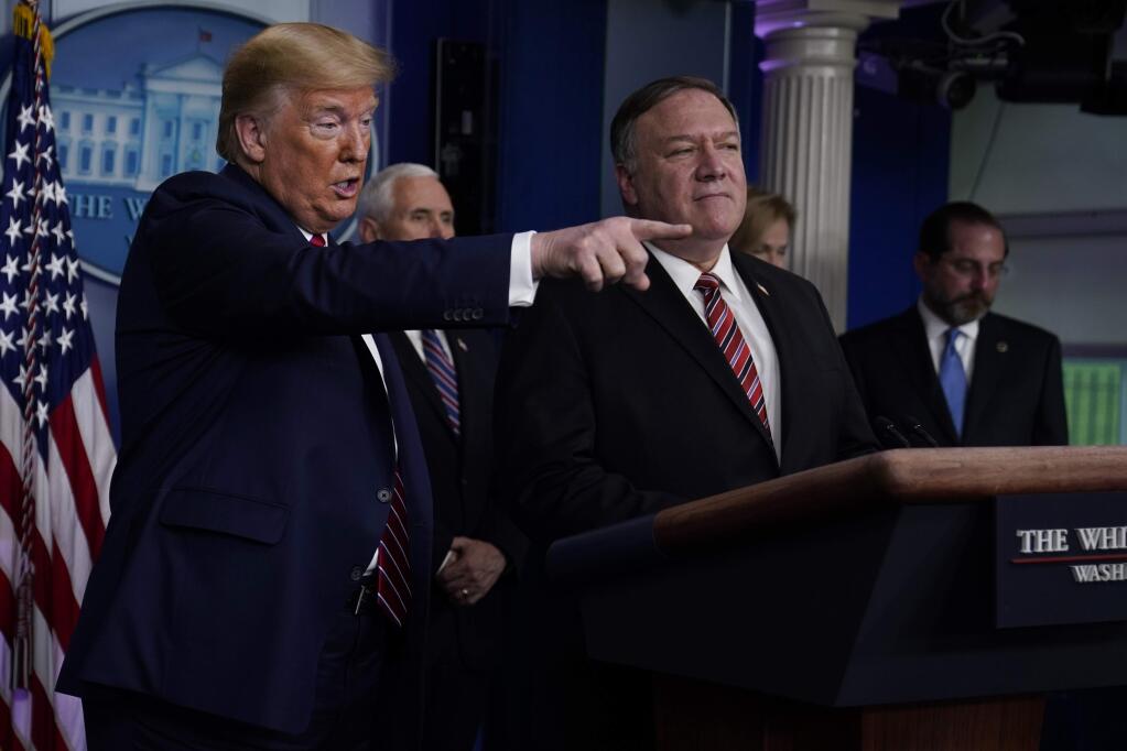 Secretary of State Mike Pompeo listens as President Donald Trump speaks during a coronavirus task force briefing at the White House, Friday, March 20, 2020, in Washington. (AP Photo/Evan Vucci)
