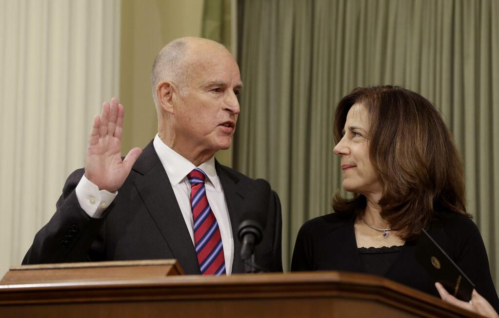 California Gov. Jerry Brown takes the oath of office as his wife, Anne Gust Brown, looks on during his inauguration at the state Capitol Monday, Jan. 5, 2015, in Sacramento, Calif. When Brown takes the oath of office Monday, it will be the first time a California governor will be sworn in to a fourth term. The 76-year-old Democrat, who held office from 1975 to 1983 before term limits and returned for a third term in 2011, delivered a joint inauguration and state of the state address in the Assembly chamber at the state Capitol. (AP Photo/Rich Pedroncelli)
