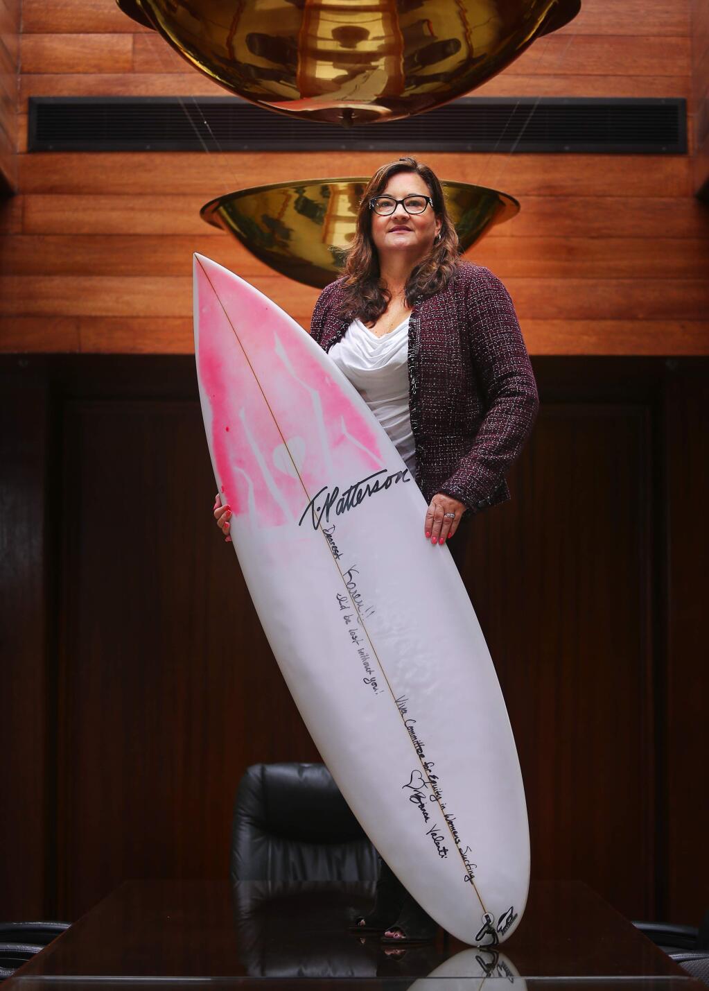 Attorney and counselor at law Karen Tynan represented a group of professional big-wave surfers that won a court decision that requires the annual Mavericks big-wave surfing contest to award equal pay for both female and male surfers. Surfer Bianca Valenti gave her an autographed board in appreciation.(Christopher Chung/ The Press Democrat)