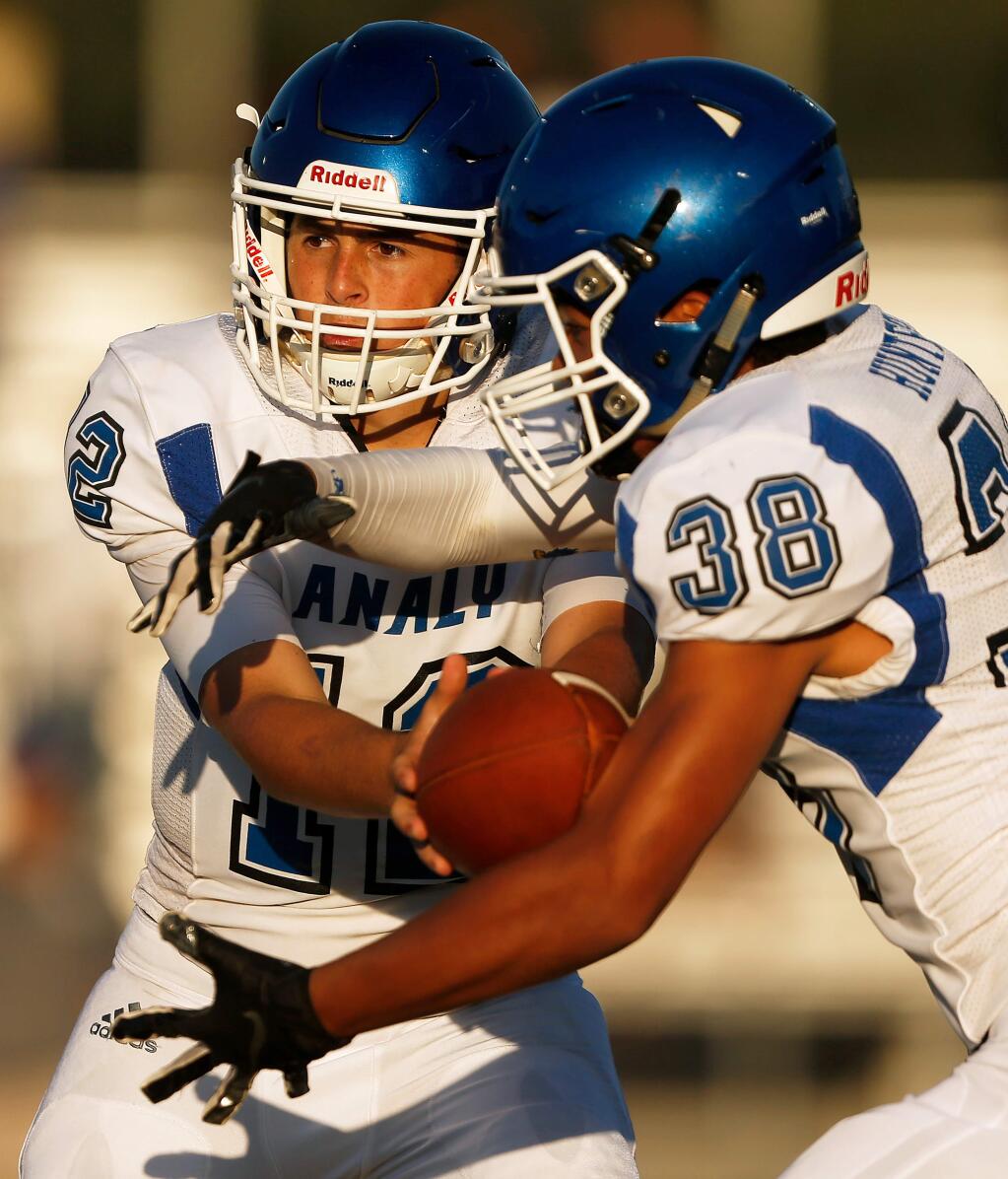 Analy quarterback Gavin Allingham, left, hands off the ball to running back Kole Hunter during the first half between Analy and Santa Rosa high schools in Santa Rosa on Friday, Aug. 23, 2019. (Alvin Jornada / The Press Democrat)