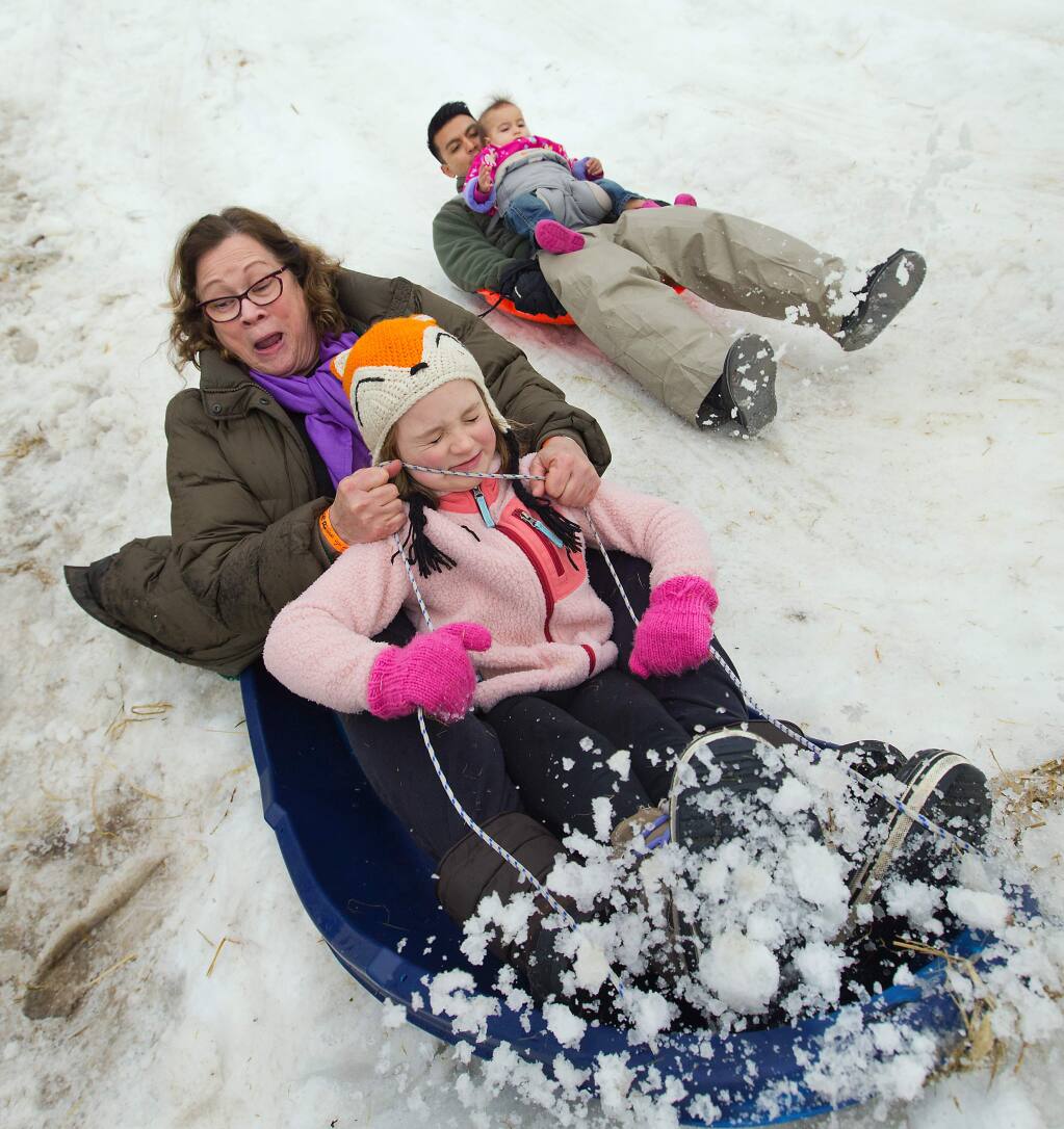 Grandma Trisha Lovejoy and Charlotte Thomas, 6, of Petaluma brace for impact at the end of toboggan hill while Mike Guevara, right, cushions daughter Penny, 2. The Children's Museum of Sonoma County brought in forty tons of fresh snow for their annual Snow Days over the Martin Luther King, Jr. Holiday Weekend. (photo by John Burgess/The Press Democrat)