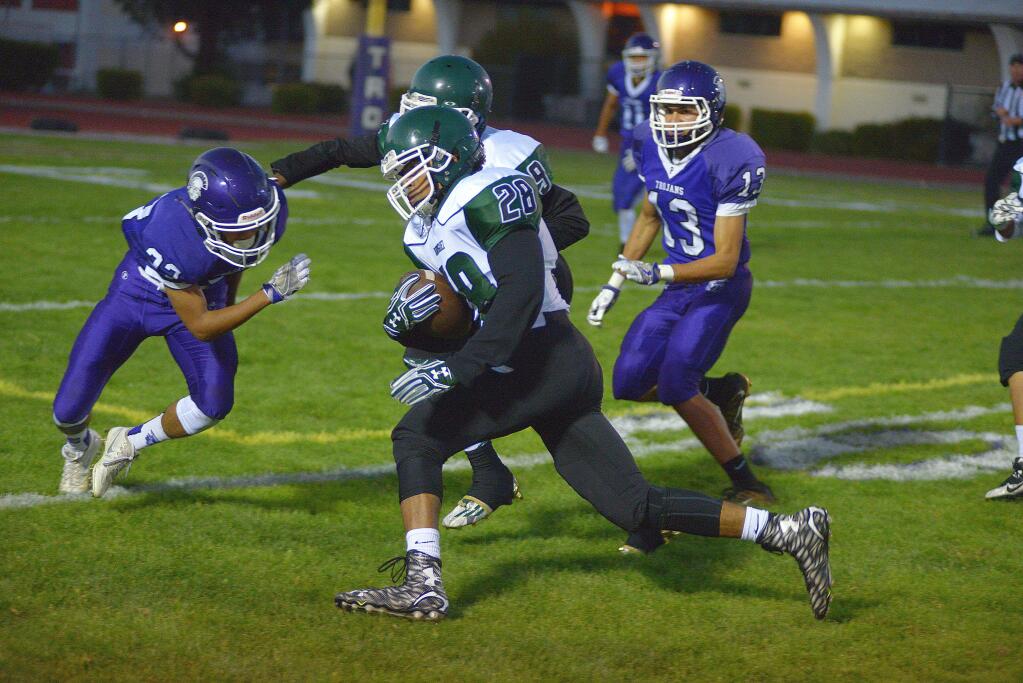 Petaluma defenders move in on Rodriguez running back Mustafah Muhammad. The Mustang back ran for 234 yards in a 42-27 win over the Trojans. (SUMNER FOWLER/FOR THE ARGUS-COURIER)