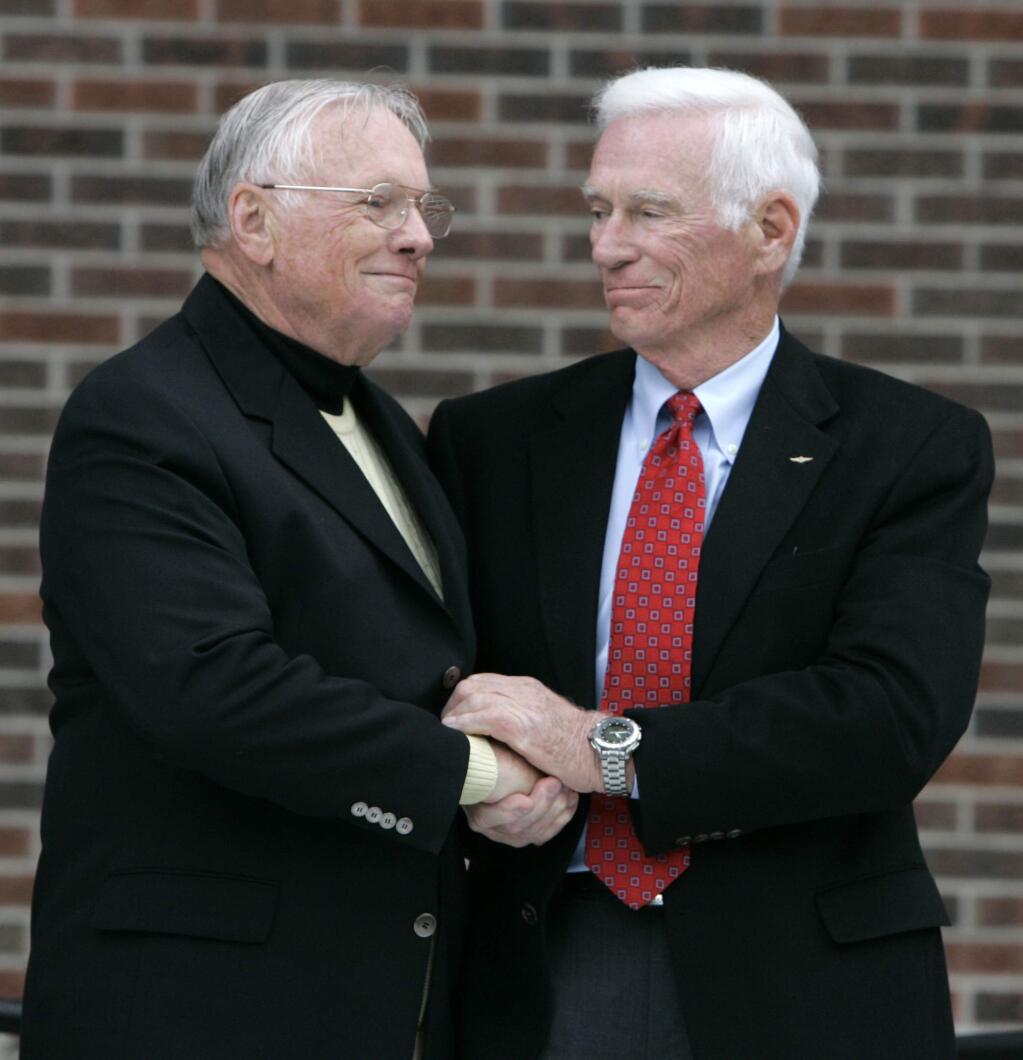 FILE - In a Oct. 27, 2007 file photo, former astronaut Neil Armstrong, left, is congratulated by fellow ex-astronaut Gene Cernan following the dedication ceremony of the Neil Armstrong Hall of Engineering at Purdue University in West Lafayette, Ind. NASA announced that former astronaut Gene Cernan, the last man to walk on the moon, died Monday, Jan. 16, 2017, surrounded by his family. He was 82. (AP Photo/Michael Conroy, File)