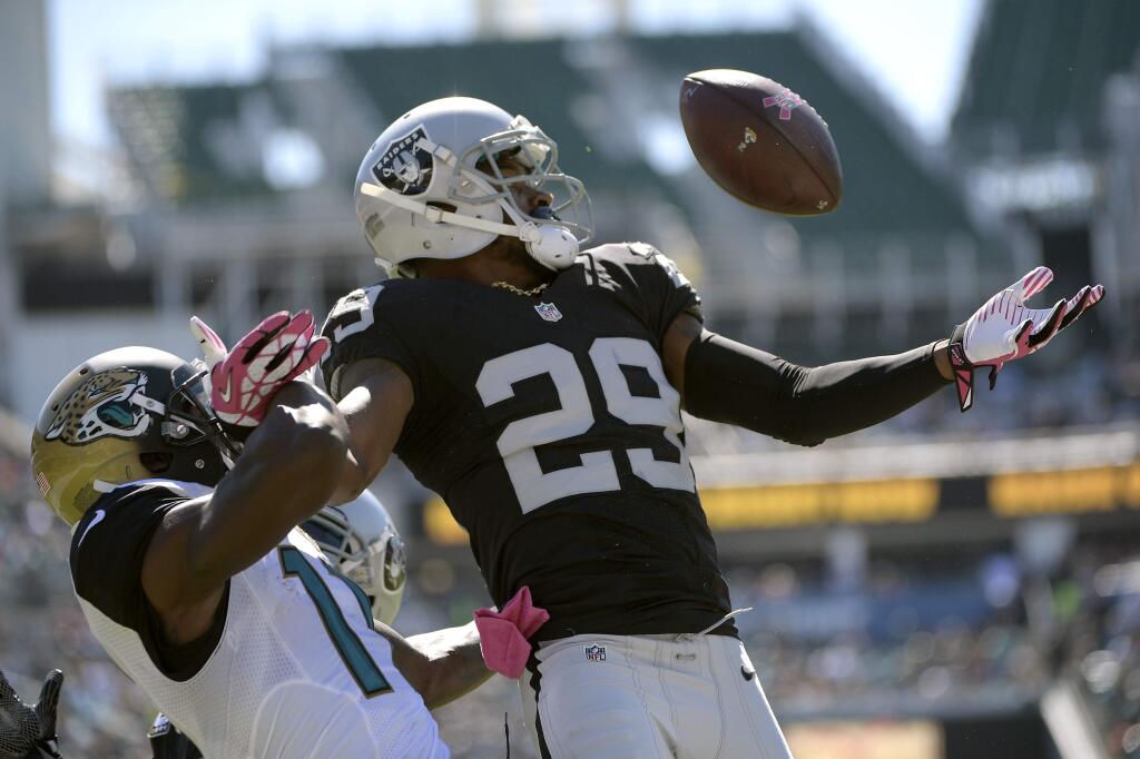 Oakland Raiders cornerback David Amerson (29) intercepts a pass intended for Jacksonville Jaguars wide receiver Marqise Lee (11) during the first quarter Sunday, Oct. 23, 2016, in Jacksonville, Fla. (AP Photo/Phelan Ebenhack)